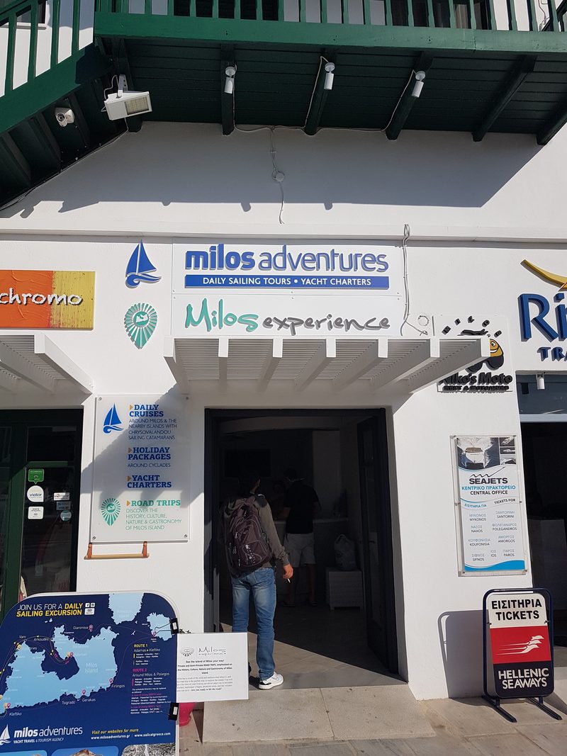 Ferry ticket agencies and a rental office along the harbour front in Adamas