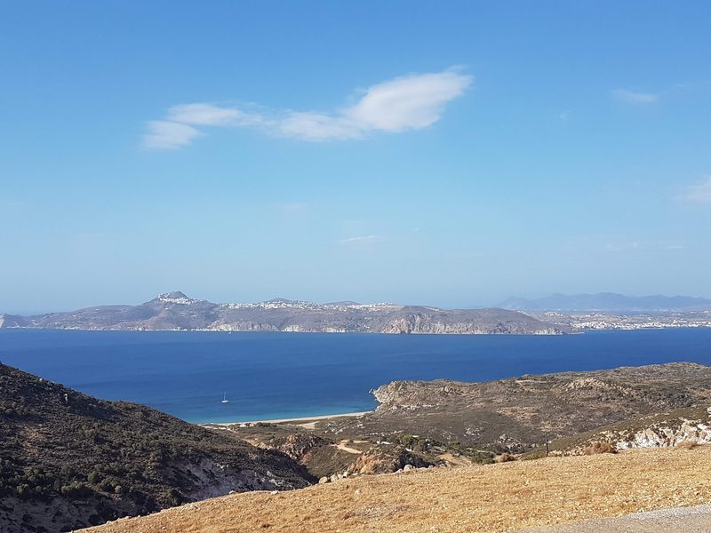 Looking down from the approach road toward the small bay and beach at Firiplaka on Milos's south coast
