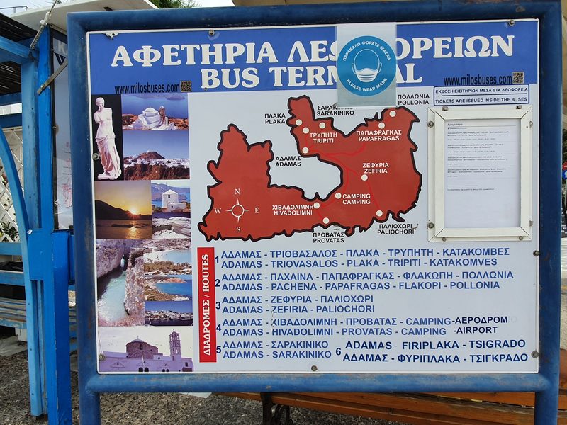 The Milos bus terminal signboard in Adamas, showing the island's numbered bus routes