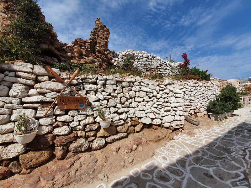 A small taverna sign built into the kastro's dry stone wall in Chorio, Kimolos