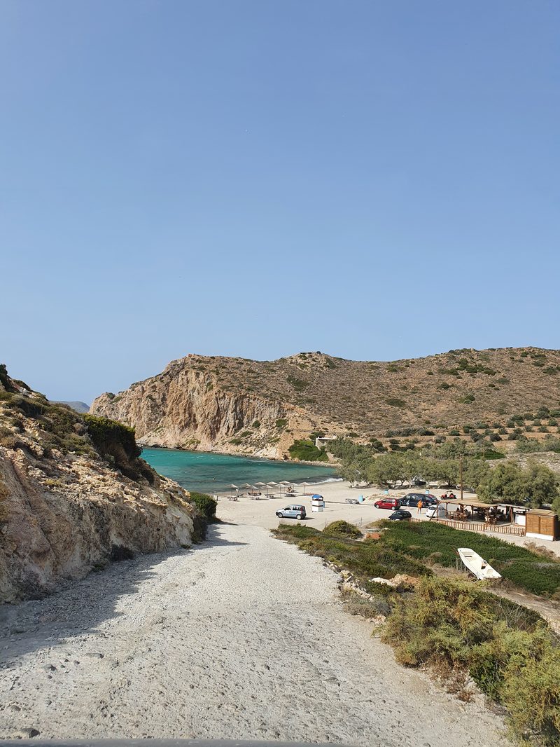 A dirt road leads down to a secluded beach on the Greek island of Milos