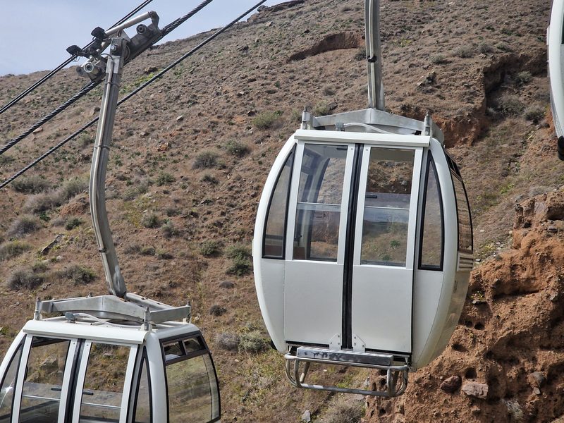 The fact that Santorini needs a cable car to transport the cruise ship visitors is indication enough that it is busier than Milos