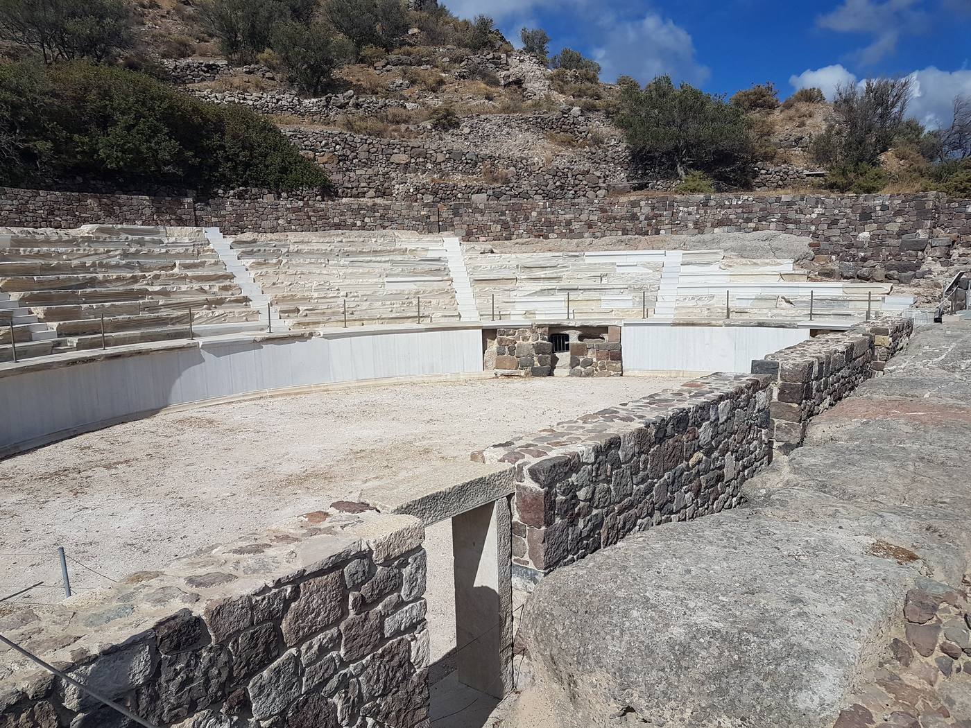 Curved rows of white marble seating at the ancient theatre near Trypiti, Milos