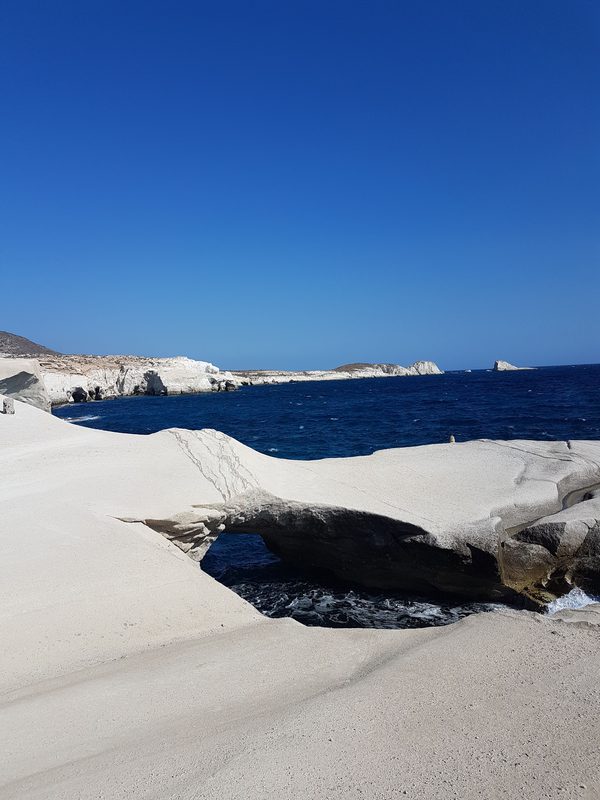 The white rock of Sarakiniko in the hard, bright light of a June afternoon, with deep blue water below